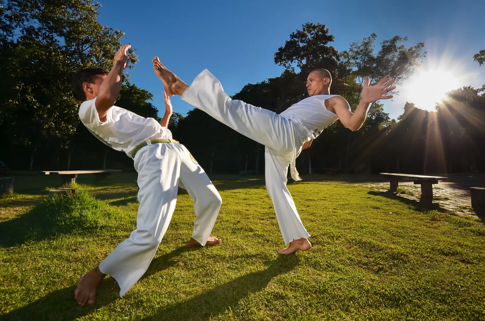 Dois atletas executando movimentos de artes marciais ao ar livre