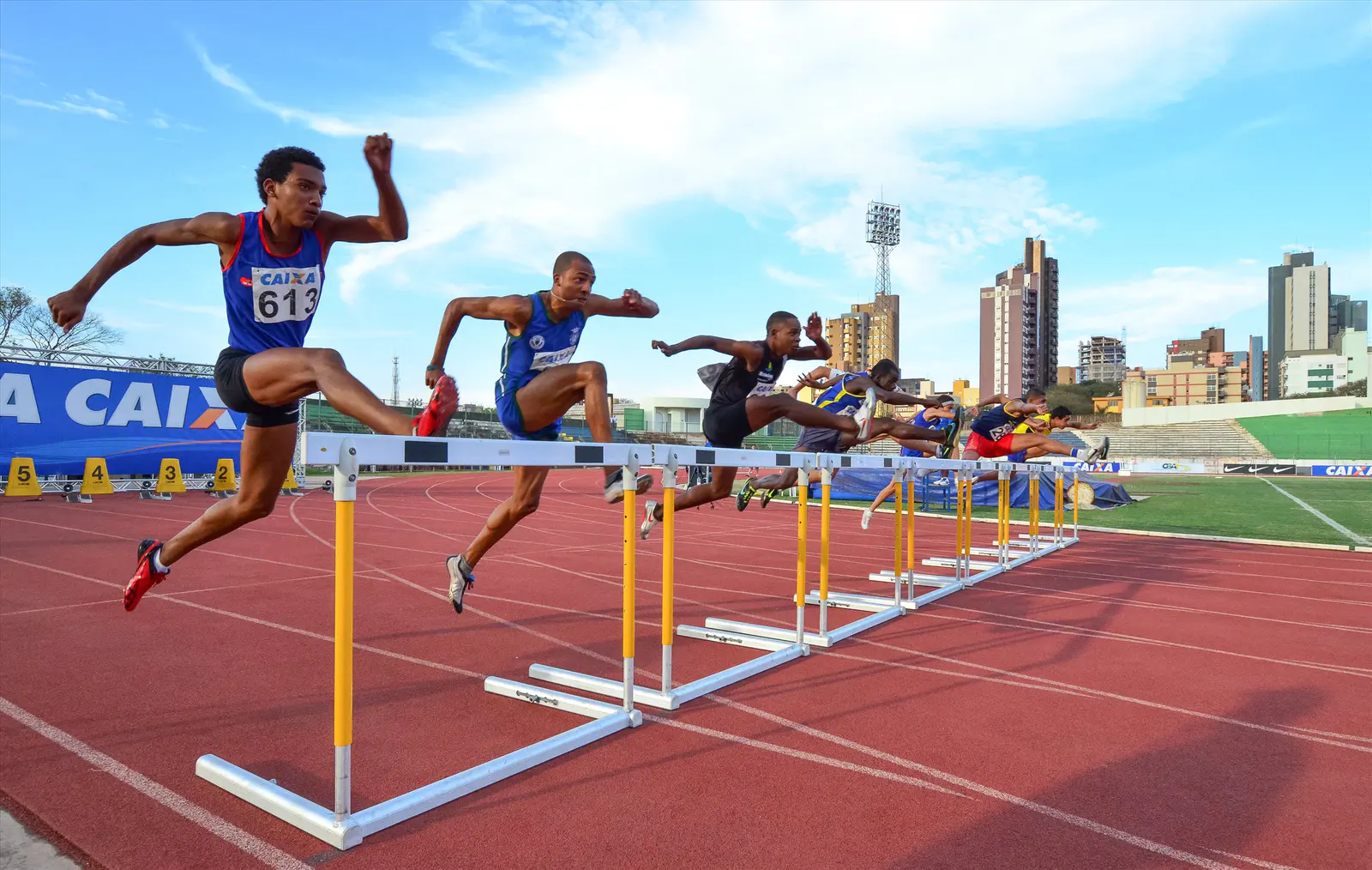 Atletas saltando barreiras em uma prova de atletismo